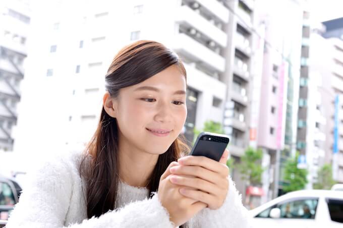 スマホで調べ物をする女性